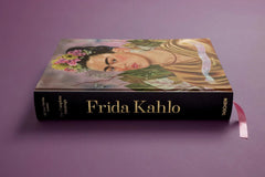 Angled view of the large hardback and its dark spine — Frida Kahlo.